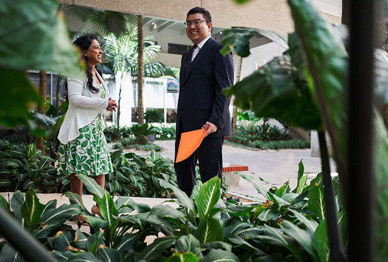 female and male graduate students talking outside the business building